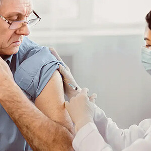 elderly male receiving immunization in pharmacy